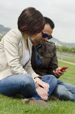 Açık parkta çift sendins sms veya görünümlü telefon resimleri