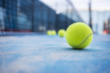  Mavi çim sahada sarı tenis topları