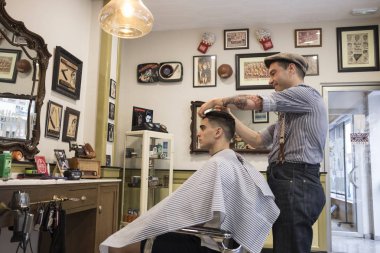 Barber shop, man cuts person hair clipart