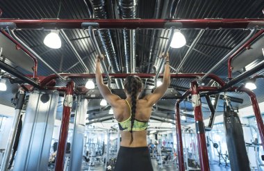 Kadınlar spor salonunda çene kaldırma egzersizleri yapıyor.