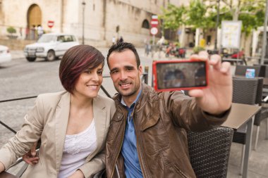 Akıllı telefon ortam ışığı ile selfie çekerek açık hava bar terasında çift