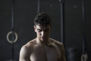 Spor salonunda dinlenen ve dinlenen güçlü gövdeli adam