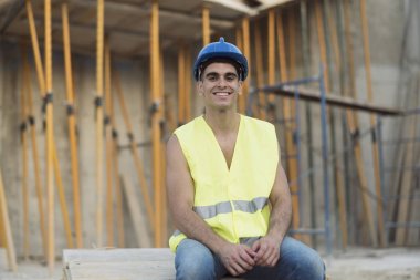 Kameraya bakarak dinlenen inşaat işçisi