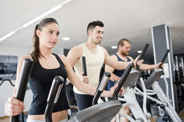 Grupo Con Mujeres Jóvenes Hombres Entrenamiento Elíptico Haciendo Ejercicio Gimnasio — Foto de Stock