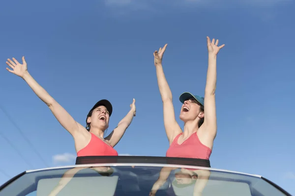 Two women in roof car with funny and freedom expression