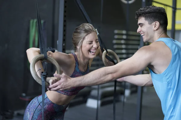 Man helps laughing  woman with ring training