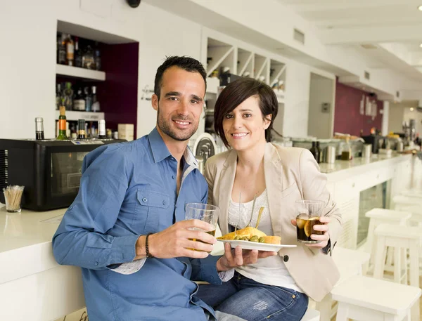 Couple in bar having date, eating and drinking with ambient window lights