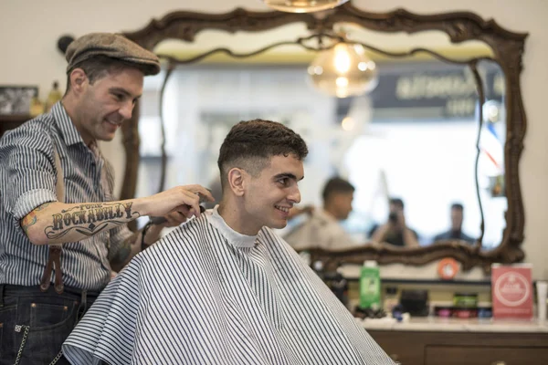 Barbier, homme coupe les cheveux de la personne — Photo