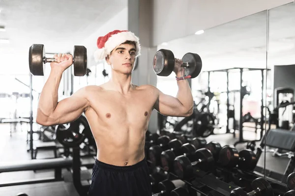 Joven Con Santa Claus Ejercicio Hombro Entrenamiento Sombrero Navidad Gimnasio — Foto de Stock