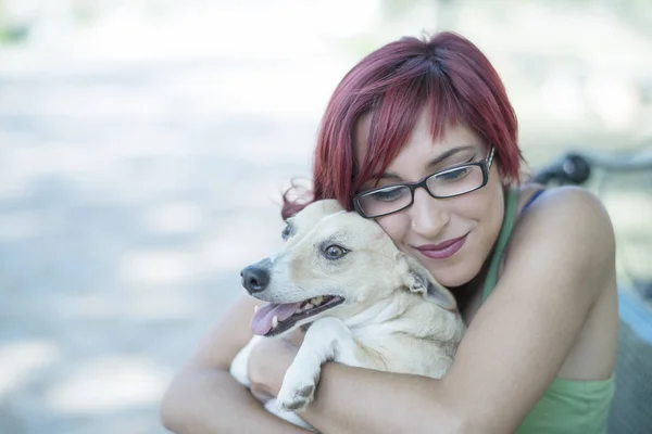 Happy woman holding dog outdoors