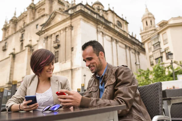 Young couple with ambient light at bar terrace with smartphones