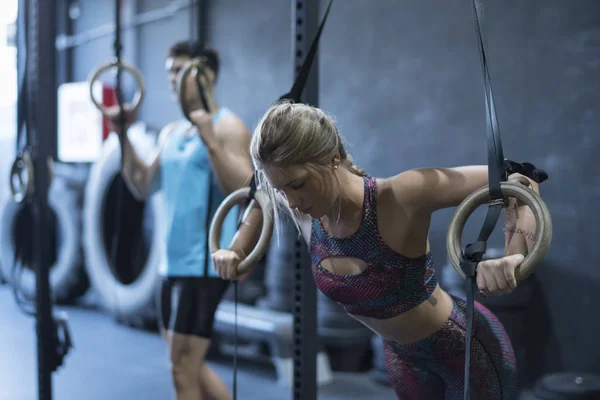 Women training olympic ring in crossfit room