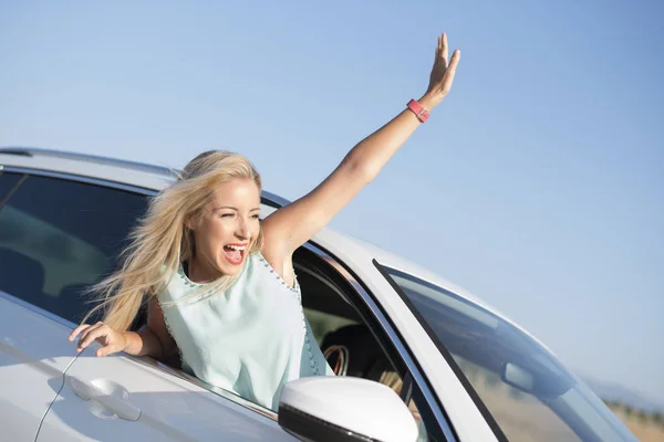 Happy smiling woman in car very happy out of window with funny expression