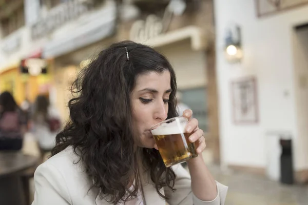 Woman drinking beer in bar terrace