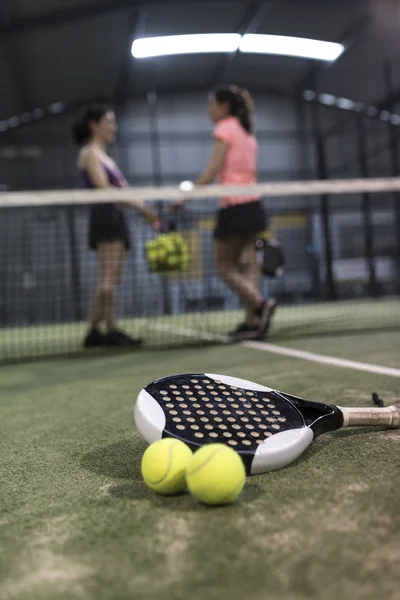 在草坪上准备比赛的球拍网球对象和背景中的妇女 — 图库照片