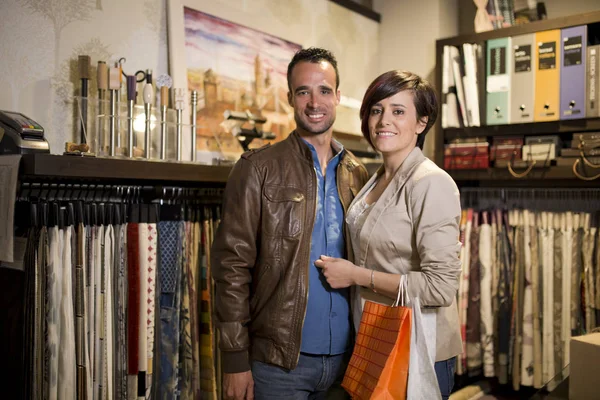 Shopping couple choosing cloths at home decoration store
