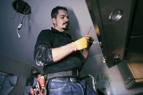 Hombre profesional reparación de luces de cocina — Foto de Stock