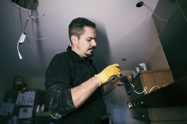 남자는 가정용 부엌에서 전기 빛을 repainring, 실내 — 스톡 사진
