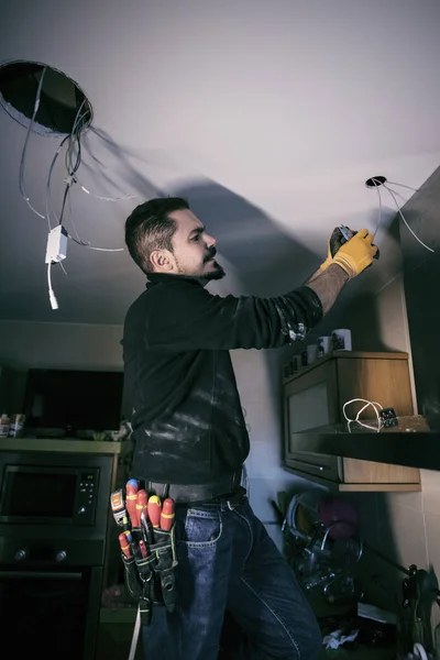 Hombre reparación e instalación de electricidad en la cocina del hogar — Foto de Stock