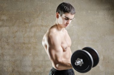 Genç adam ağırlık kaldırıyor.