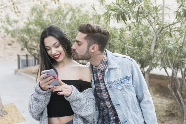 Man seduces woman while she looks at the phone in the city