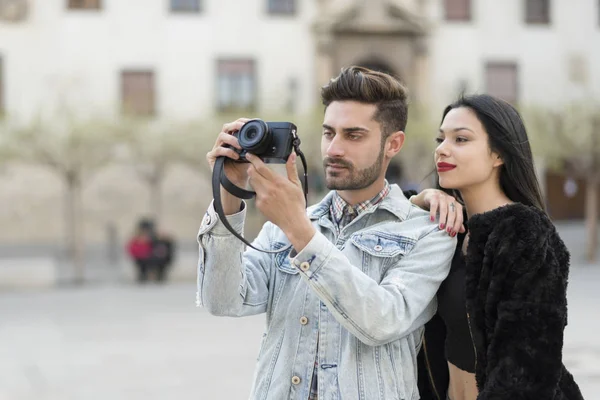 Young couple taking pictures in city outdoors at european travel