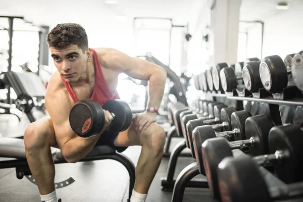 Joven hombre entrenando pesas en gimnasio — Foto de Stock