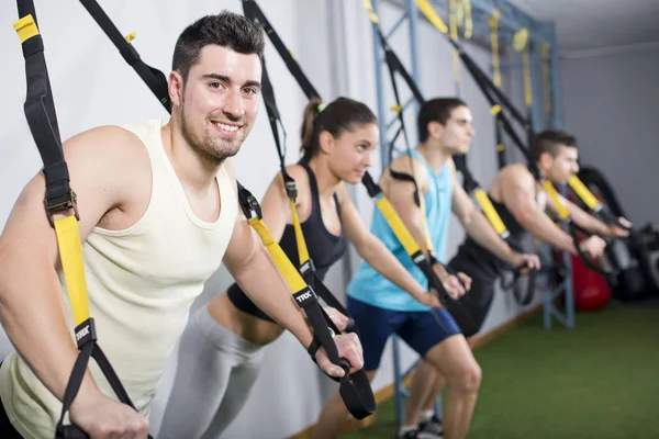 Pessoas treinando em exercícios de suspensão no ginásio — Fotografia de Stock