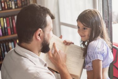 Baba ve kızı pencere ve baba açıklayan yakın kitap okuma
