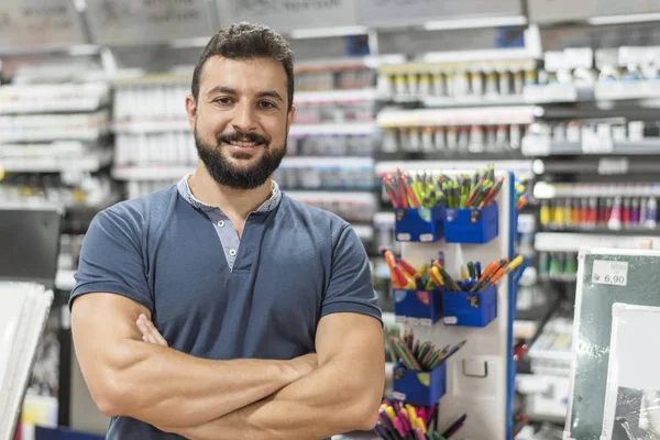 Atractiva trabajadora en papelería posa con los brazos cruzados mirando — Foto de Stock