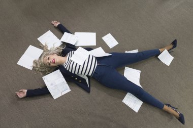 Klişe görüntü stresli kağıtları ile ofiste yatan stresli kadın