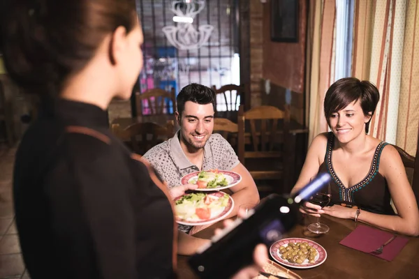 Garson barda sipariş veriyor ve çifte şarap ikram ediyor.