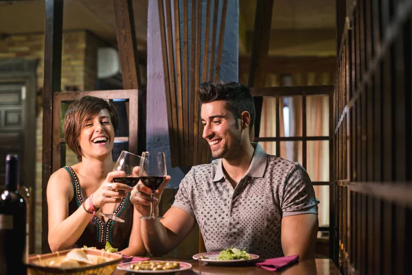 Bardaki çift geleneksel restoranda gülümsüyor ve içiyor.