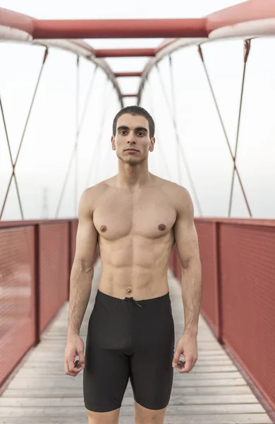 赤い橋の上で訓練した後のランナーストレッチ — ストック写真