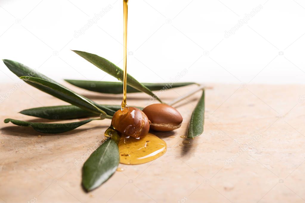 argan oil pouring over argan seeds