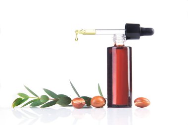 Beyaz üzerine bir şişe argan yağı.