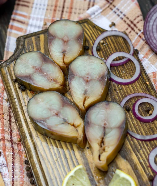 Füme balık, scambria bir ahşap tahta ve soğan ve limon dilimleri.