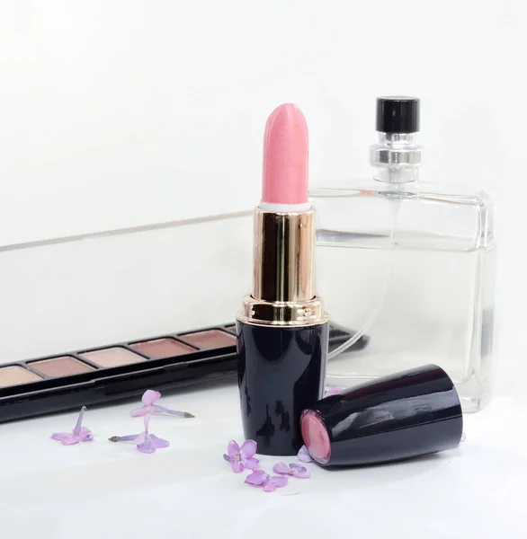 Kadınlar için kozmetik, pomade, gölgeler ve hafif bir arka plan üzerinde parfüm. Seçici odaklama.