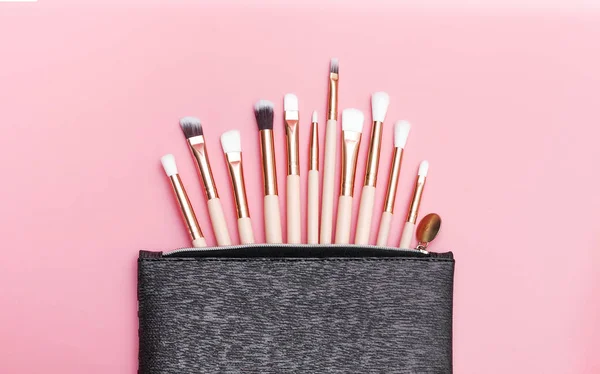 Makyaj fırçaları. Pembe arka plan üzerinde fırçalar ile Kozmetik. Güzellik ve moda.