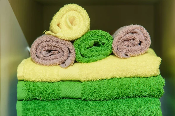 Color terry towels in the hotel. Dry and soft towels for the bathroom. Home textiles. Bathroom textiles