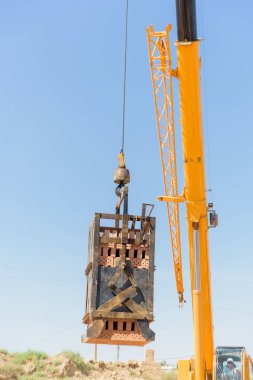 Yükleme hazır tuğla bloklar. Tuğla imalatı için bir fabrika. Yükleme tuğla vinç