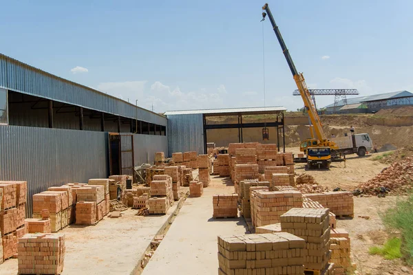 Loading ready brick blocks. A factory for the production of bricks. Crane loading bricks