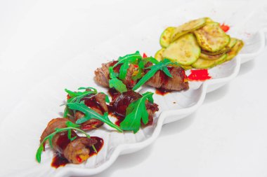 Kızarmış kabak ile et antre. Et beyaz bir tabakta sebze ile alır. Bir restoranda soğuk meze