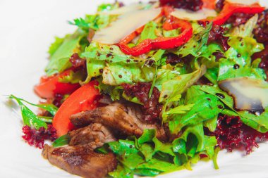 Etli sebze salatası. Beyaz tabakta et salatası. Bir restoranda soğuk meze