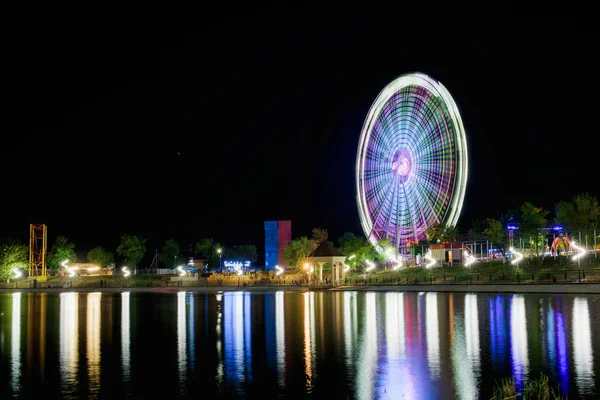 Dönme dolap Çimkent içinde. Gece şehir fotoğrafları. Uzun pozlama dönme. Kazakistan'ın eğlence parkı