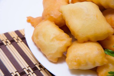 Beyaz bir tabak kızarmış baursaks. Kazak baursaks. Kazak hafif bir arka plan üzerinde ekmek. Kızarmış hamur dolum olmadan. Doğu ulusal mutfağı. Orta Asya mutfağı yemek. Kazak ekmek