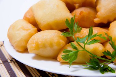 Beyaz bir tabak kızarmış baursaks. Kazak baursaks. Kazak hafif bir arka plan üzerinde ekmek. Kızarmış hamur dolum olmadan. Doğu ulusal mutfağı. Orta Asya mutfağı yemek. Kazak ekmek