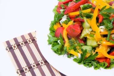 Taze salata beyaz tabakta. Sebze bir tabağa dilimlenmiş. Soğuk Aperatif bir kafede. Salata yeşillikleri ile