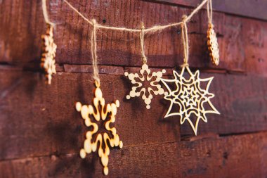 Ahşap arka plan üzerinde Noel kar taneleri. Noel ağacı süsleme için çevre dostu oyuncaklar. Dekorasyon için ağaç ürünleri. Noel dekorasyon kontrplak yaptı