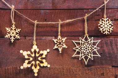 Ahşap arka plan üzerinde Noel kar taneleri. Noel ağacı süsleme için çevre dostu oyuncaklar. Dekorasyon için ağaç ürünleri. Noel dekorasyon kontrplak yaptı